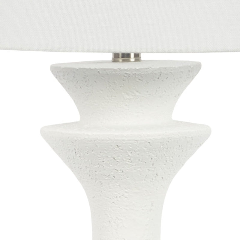 White resin table lamp close-up of speckled pedestal top under white drum shade