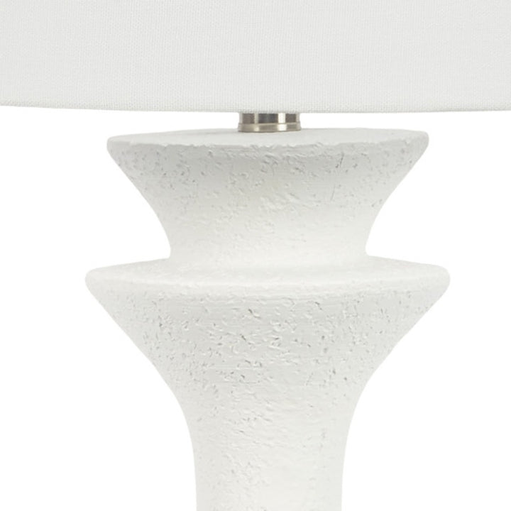 White resin table lamp close-up of speckled pedestal top under white drum shade