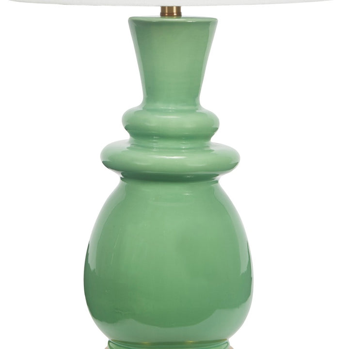 Ceramic table lamp close-up: green ceramic vase body under white shade