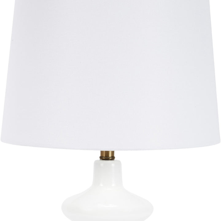 White drum shade and white glass lamp body with brass socket accents