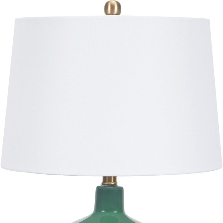Emerald green glass table lamp with white fabric shade and brass accents