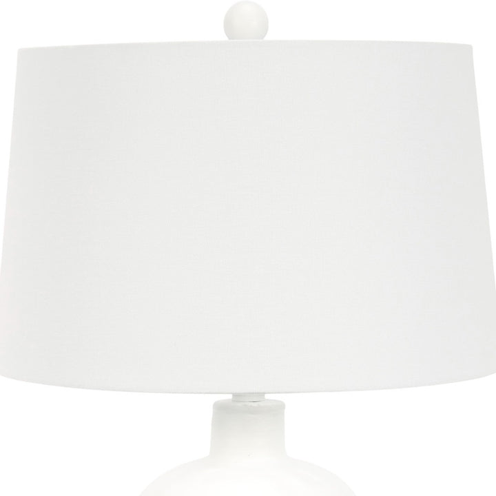 White plaster-textured table lamp with drum fabric shade