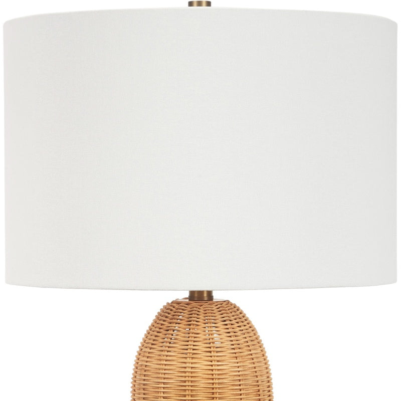 Table lamp with white linen drum shade and woven rattan base