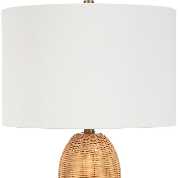 Table lamp with white linen drum shade and woven rattan base