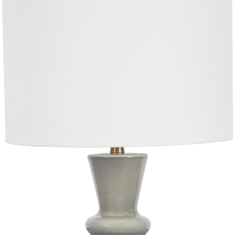 Gray ceramic table lamp with white linen drum shade and flared base
