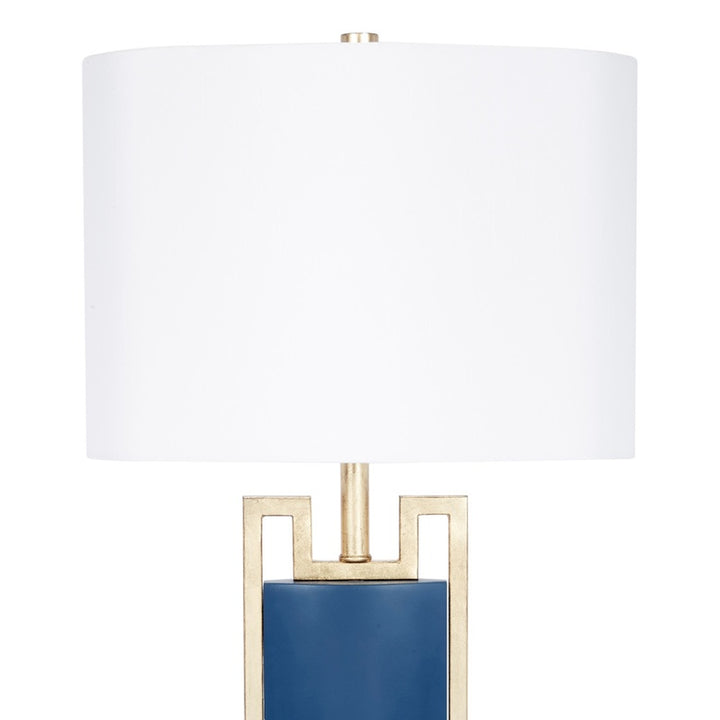 Blue table lamp with white drum shade and gold frame, blue column base.