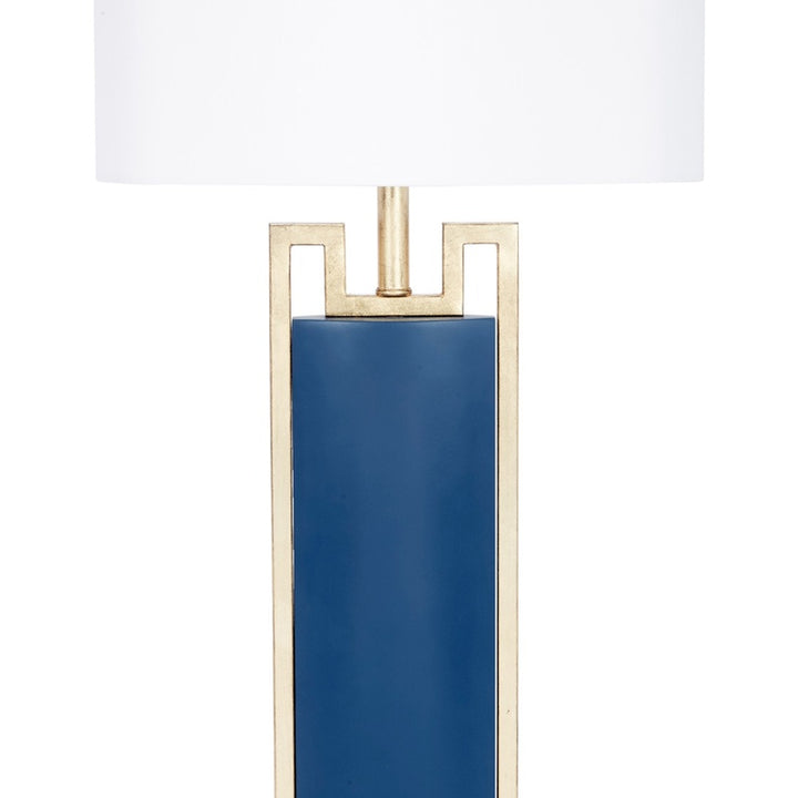 Blue table lamp with white drum shade and gold metal frame, blue column base.