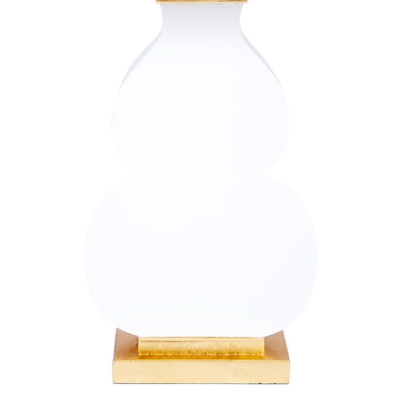 Table lamp with white glass body and gold base plate plus gold band accents beneath shade