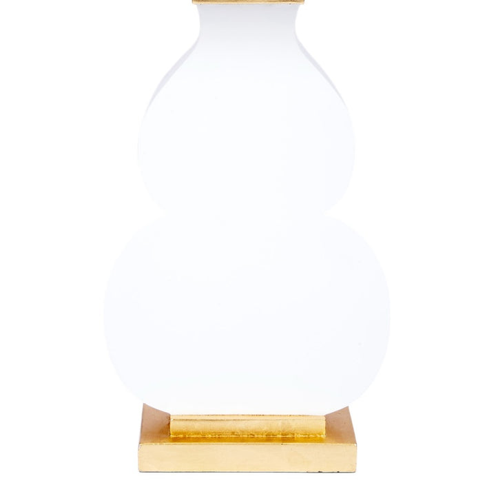 Table lamp with white glass body and gold base plate plus gold band accents beneath shade