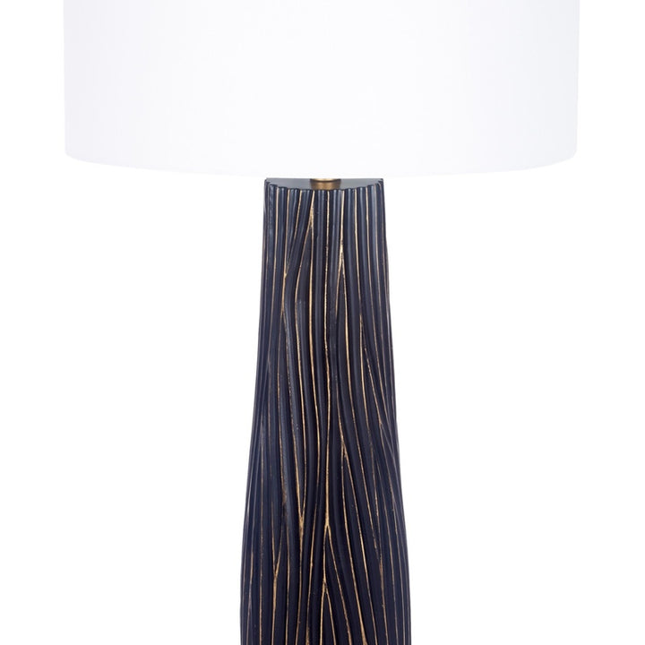 Black ribbed lamp base with gold top ring and white drum shade (partial)