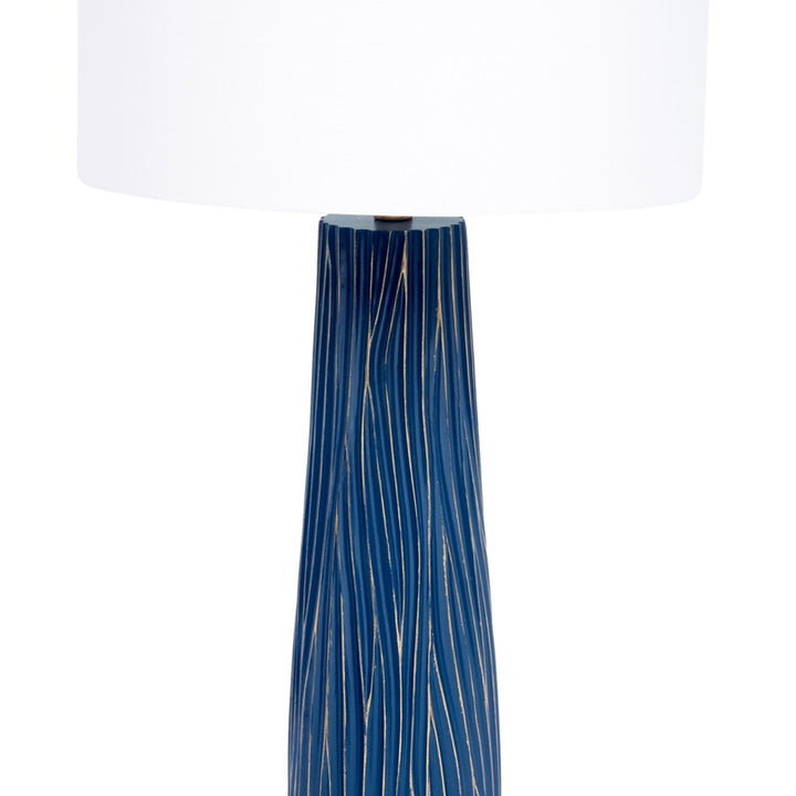 Table lamp with white drum shade and tall blue ribbed base with gold trim