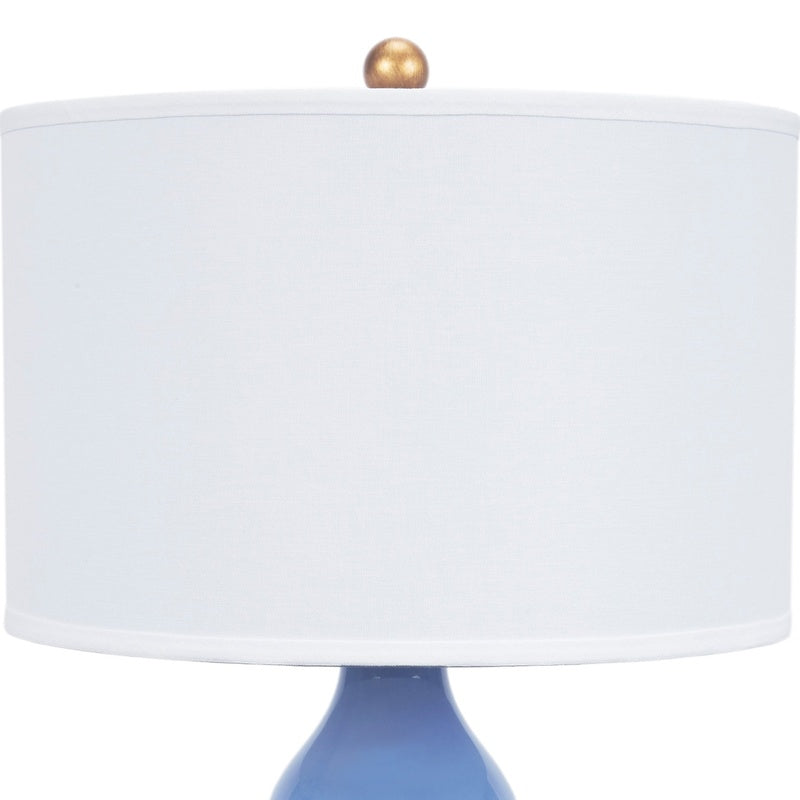 Blue porcelain table lamp with white linen fabric shade and gold finial