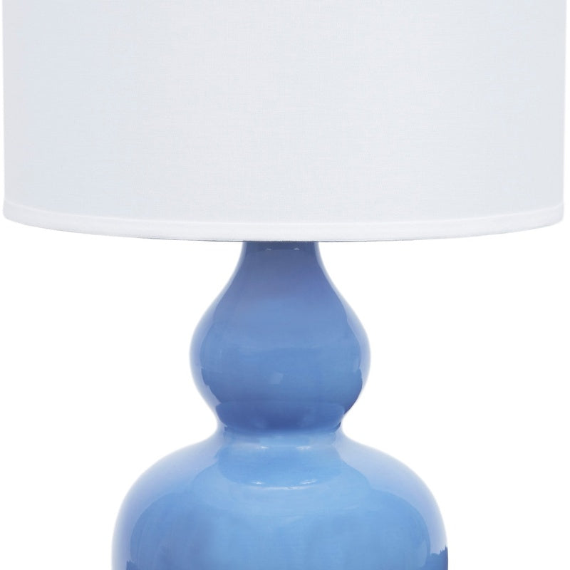 Blue porcelain lamp base with white linen drum shade and gold accents