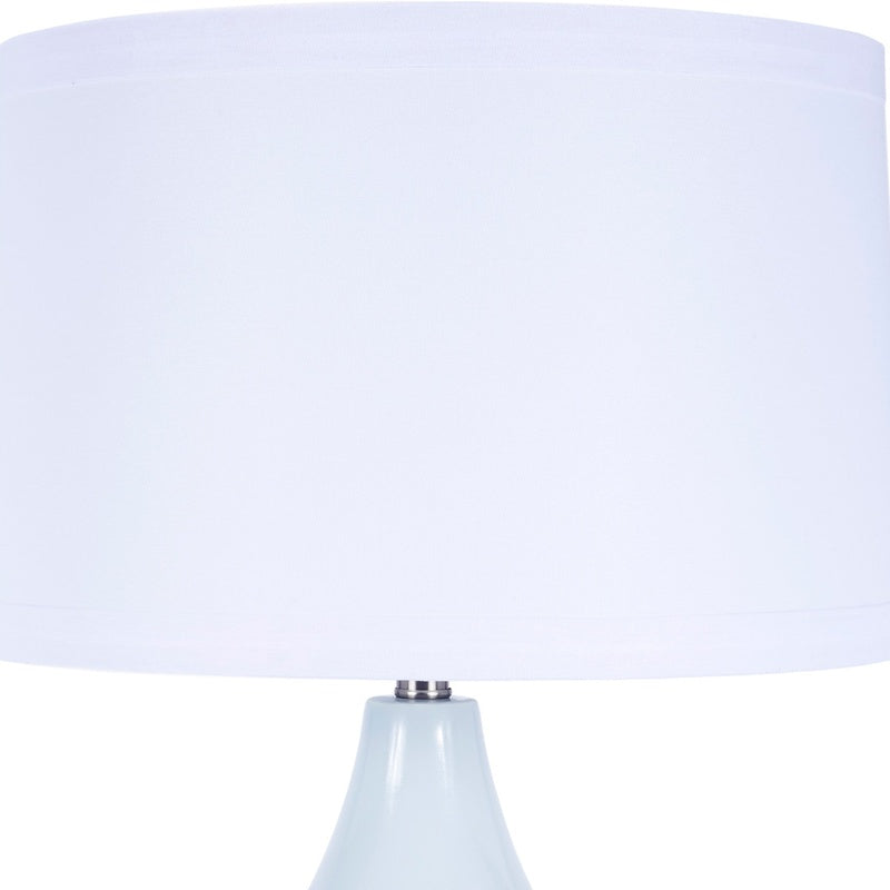 Blue ceramic table lamp with white fabric shade, upper portion