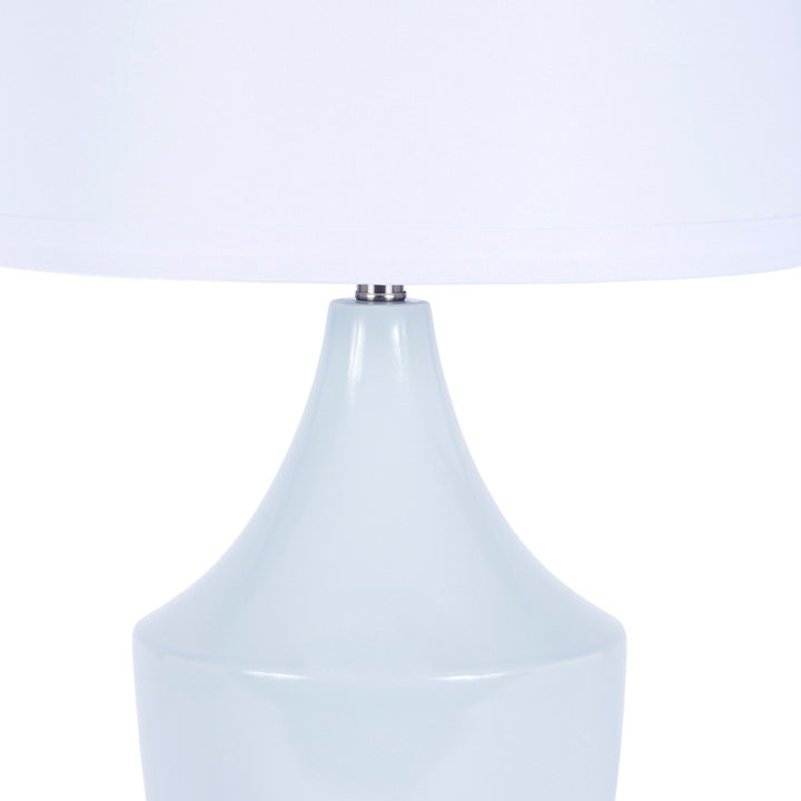 Blue ceramic table lamp with white fabric shade and rounded base