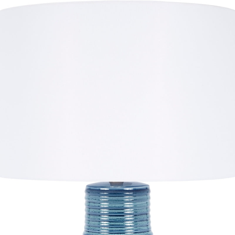 Blue ceramic table lamp with white drum shade, ribbed textured body