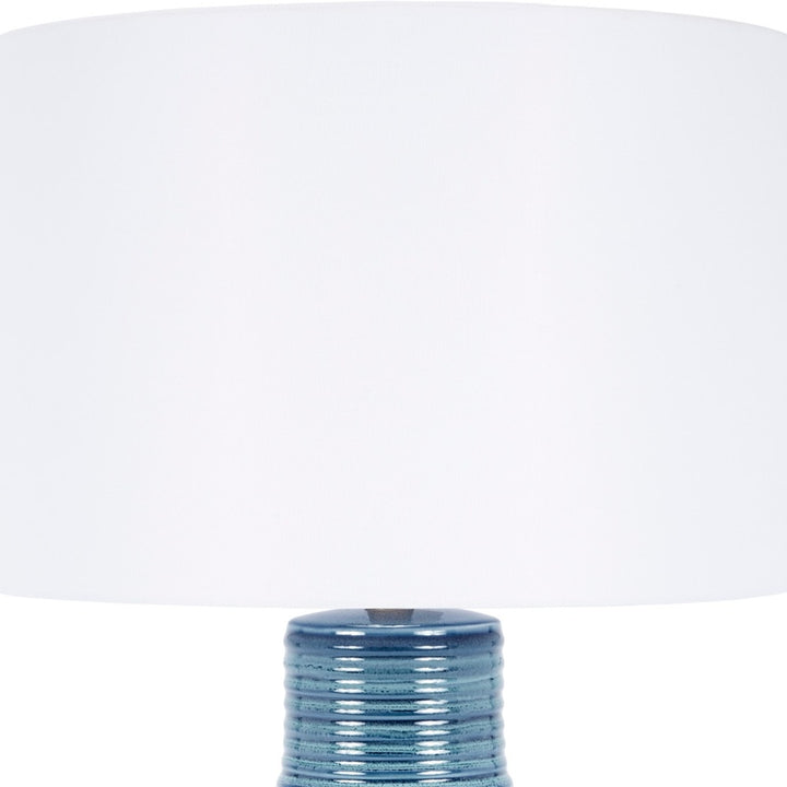 Blue ceramic table lamp with white drum shade, ribbed textured body