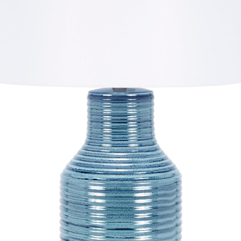 Blue ceramic lamp base under white drum shade, ribbed finish