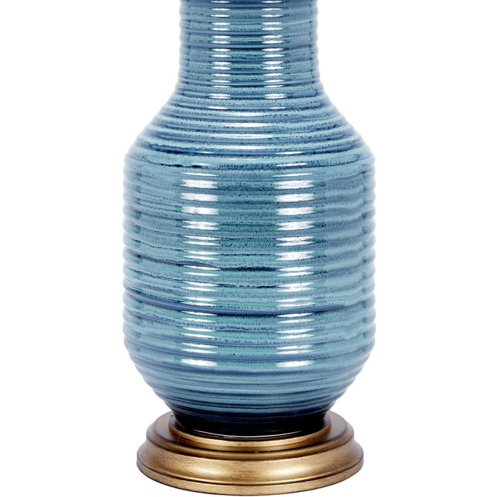 Blue ceramic table lamp with white drum shade and brass base
