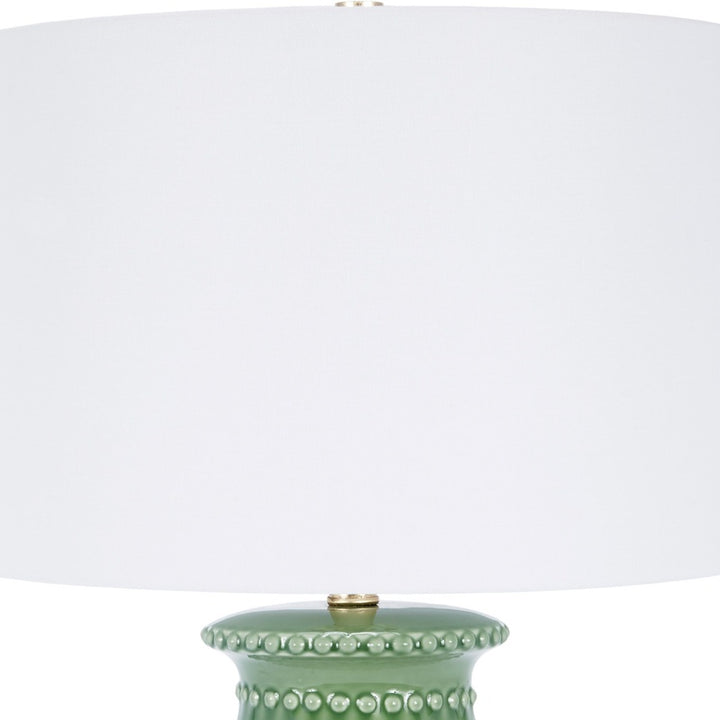 Green ceramic table lamp with white drum shade and beaded stud accents