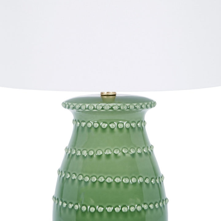 Green ceramic table lamp with white drum shade and raised stud band details