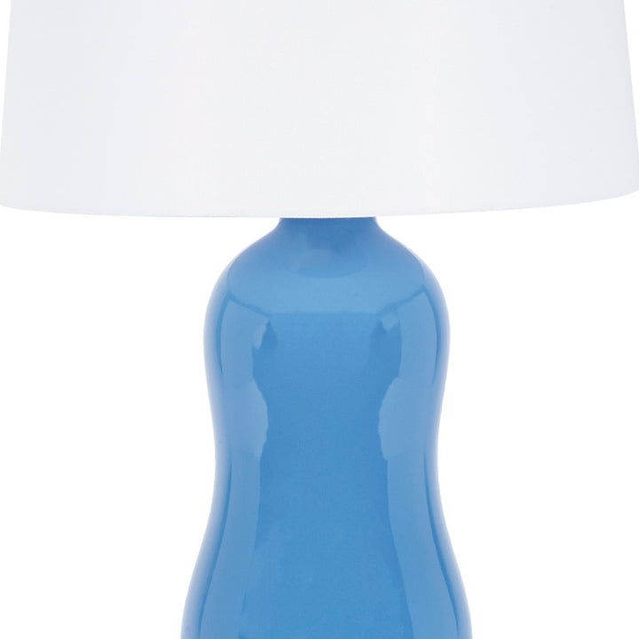Ceramic table lamp with white drum shade and blue glossy ceramic body