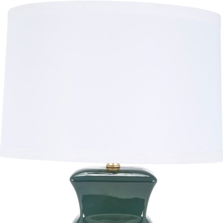 Dark green ceramic table lamp with white drum shade and brass finial