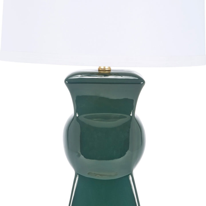 Dark green ceramic table lamp with sculpted base and white drum shade