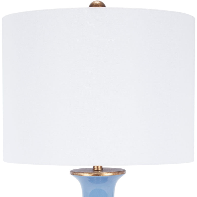 Blue ceramic table lamp with white fabric shade and brass-toned top base
