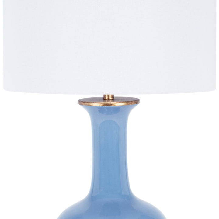 Blue ceramic table lamp with white fabric shade and brass cap detail