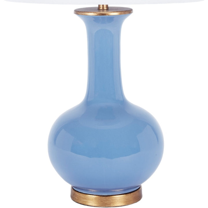 Glossy blue ceramic table lamp with white fabric shade and brass trim