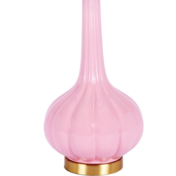 Blush pink glass table lamp base with gold-toned bottom and white drum shade