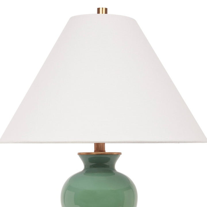 Green ceramic table lamp with white linen shade and brass accents