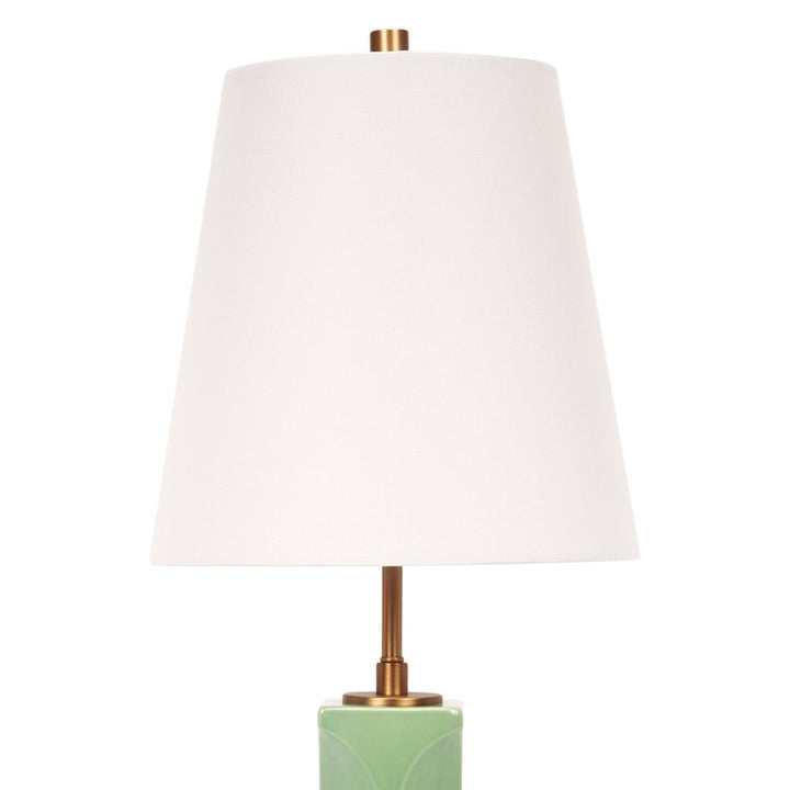 Green ceramic table lamp with white linen drum shade and brass base