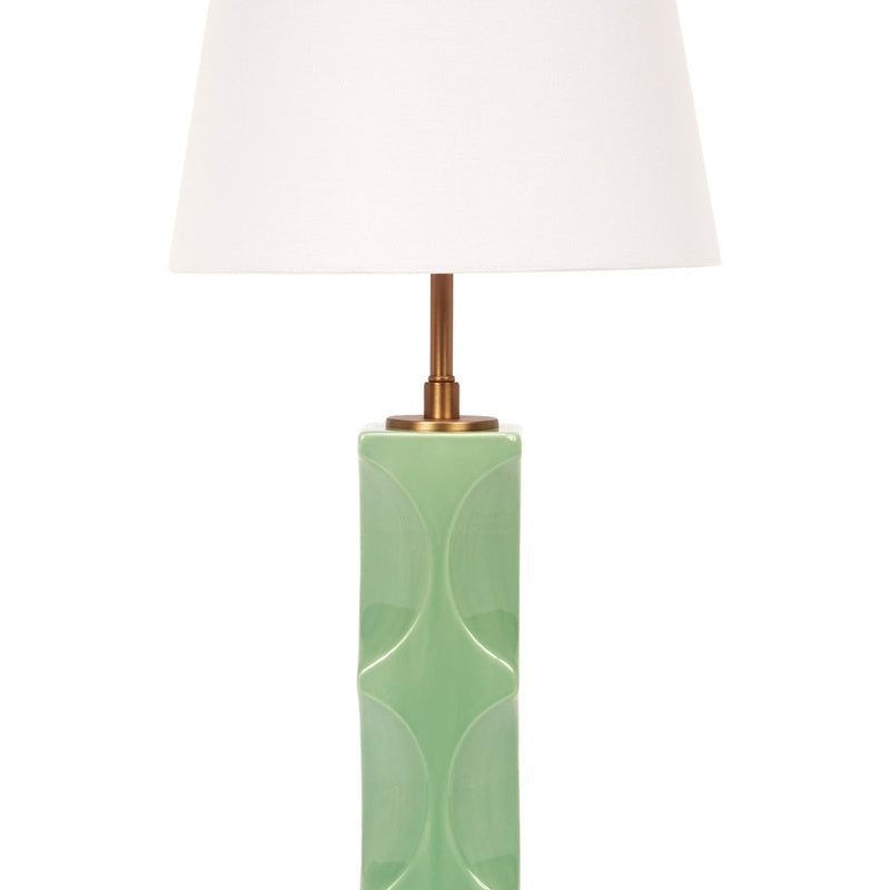 Green ceramic table lamp with white linen drum shade, brass stem and top