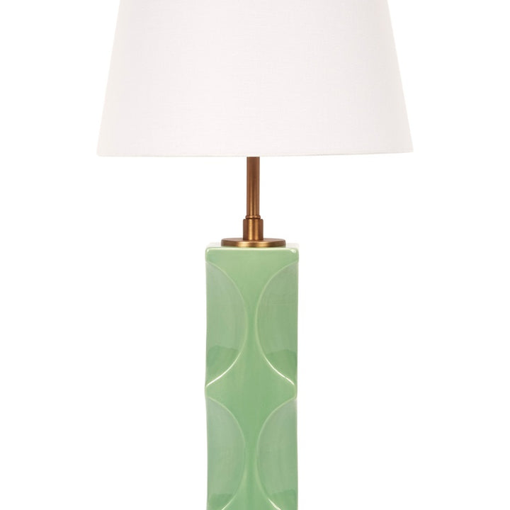 Green ceramic table lamp with white linen drum shade, brass stem and top