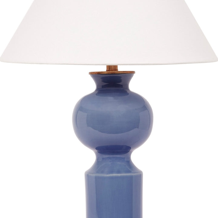 Blue ceramic table lamp with white linen shade and brass collar