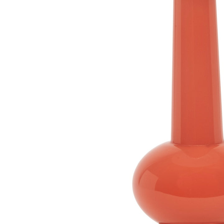Close-up of glossy orange lamp base bulb beneath the white linen shade.