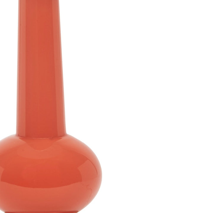 Close-up of glossy orange lamp base with slender stem above.