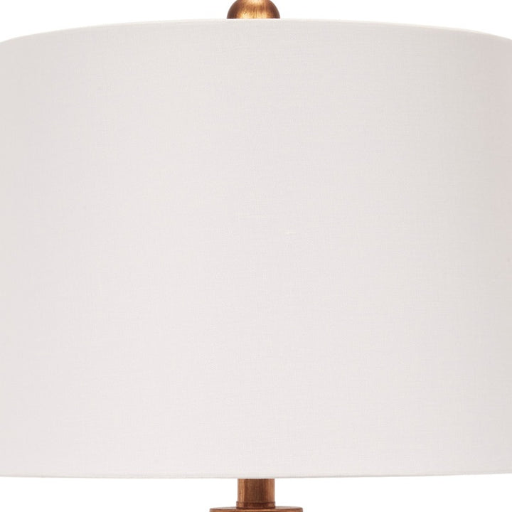 White linen drum shade with brass finial on a blue ceramic lamp body