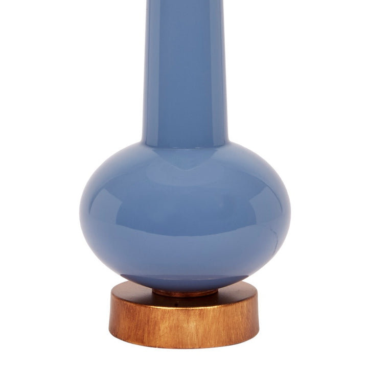 Blue ceramic buffet lamp with white linen shade, brass ring, and wooden base
