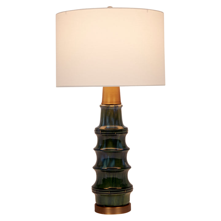 Stylish peacock green ceramic lamp with brass details, adding a pop of color and luxurious charm to any room.