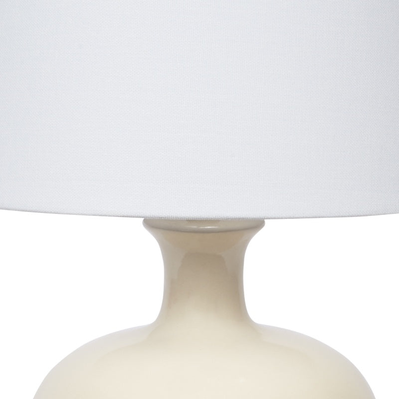 Cream ceramic table lamp body with flared neck under white linen shade