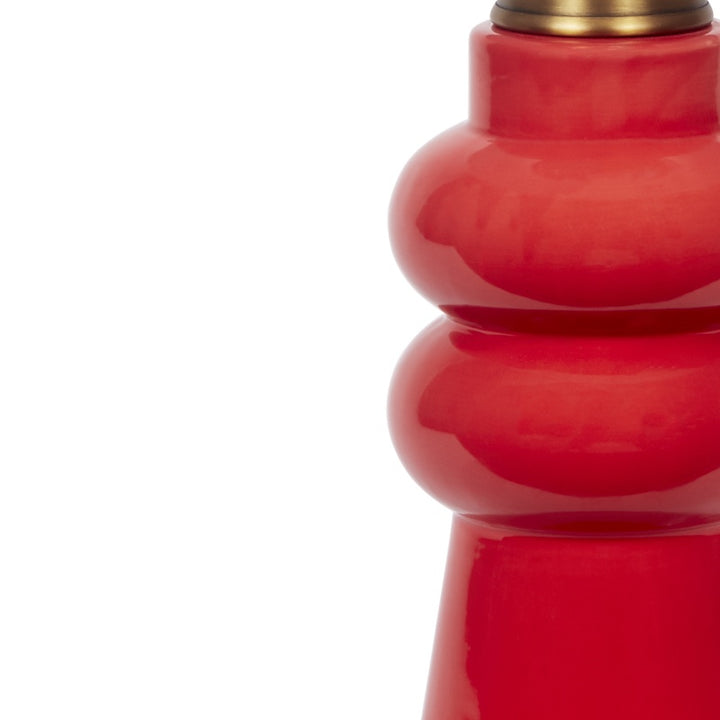 Glossy red ceramic lamp body with brass collar and partial white shade