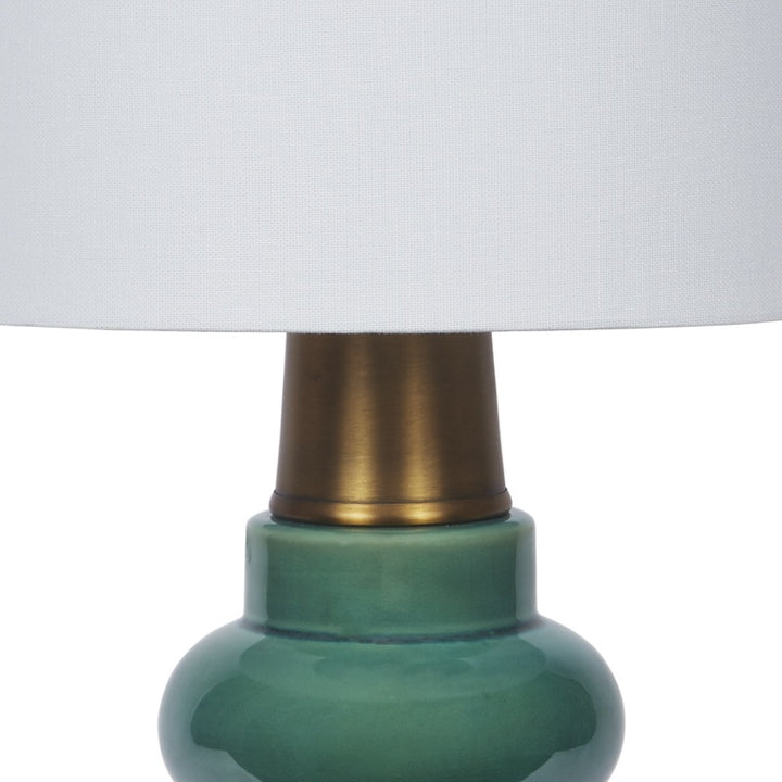 Ceramic table lamp base in forest green with brass collar under shade