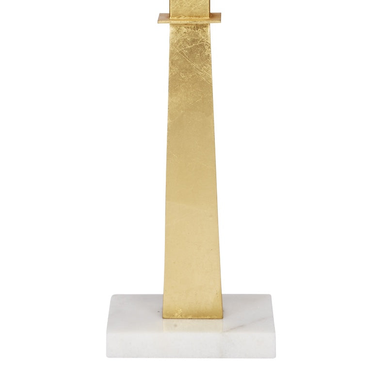 Gold faith lamp with gold leaf cross stem on white marble base