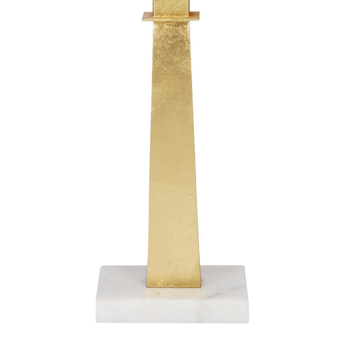 Gold faith lamp with gold leaf cross stem on white marble base