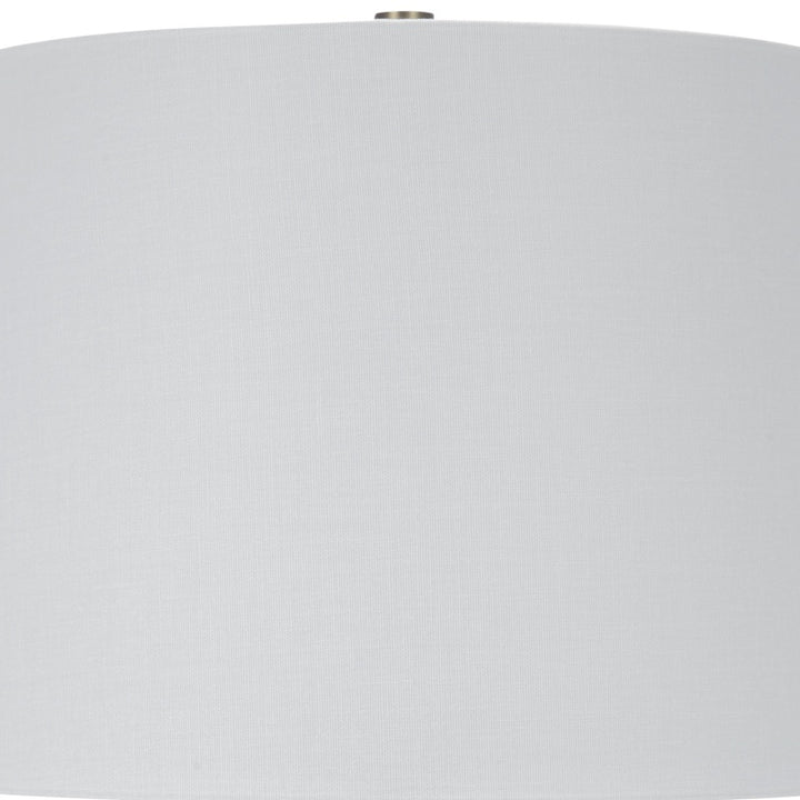 White drum lamp shade with finial on top of blue-green ceramic base