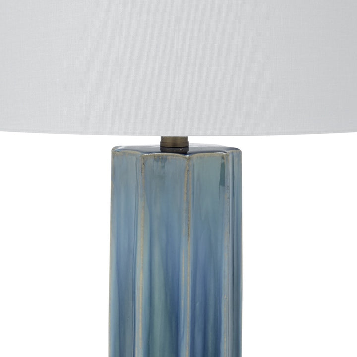 Blue-green ceramic lamp column with dark top cap under a white drum shade