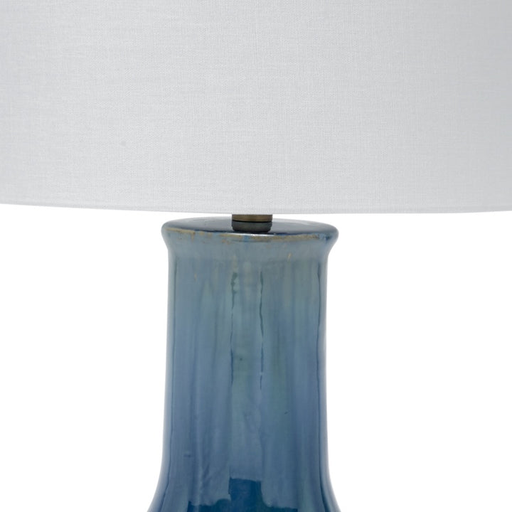 Lamp with off-white drum shade and glossy blue ceramic column base top
